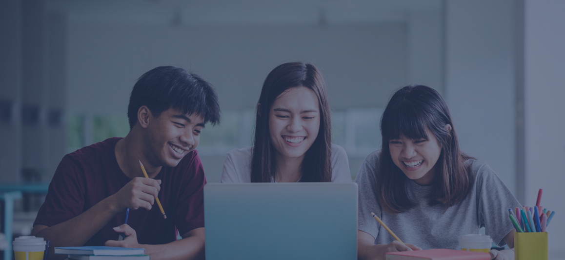 People smiling around a laptop